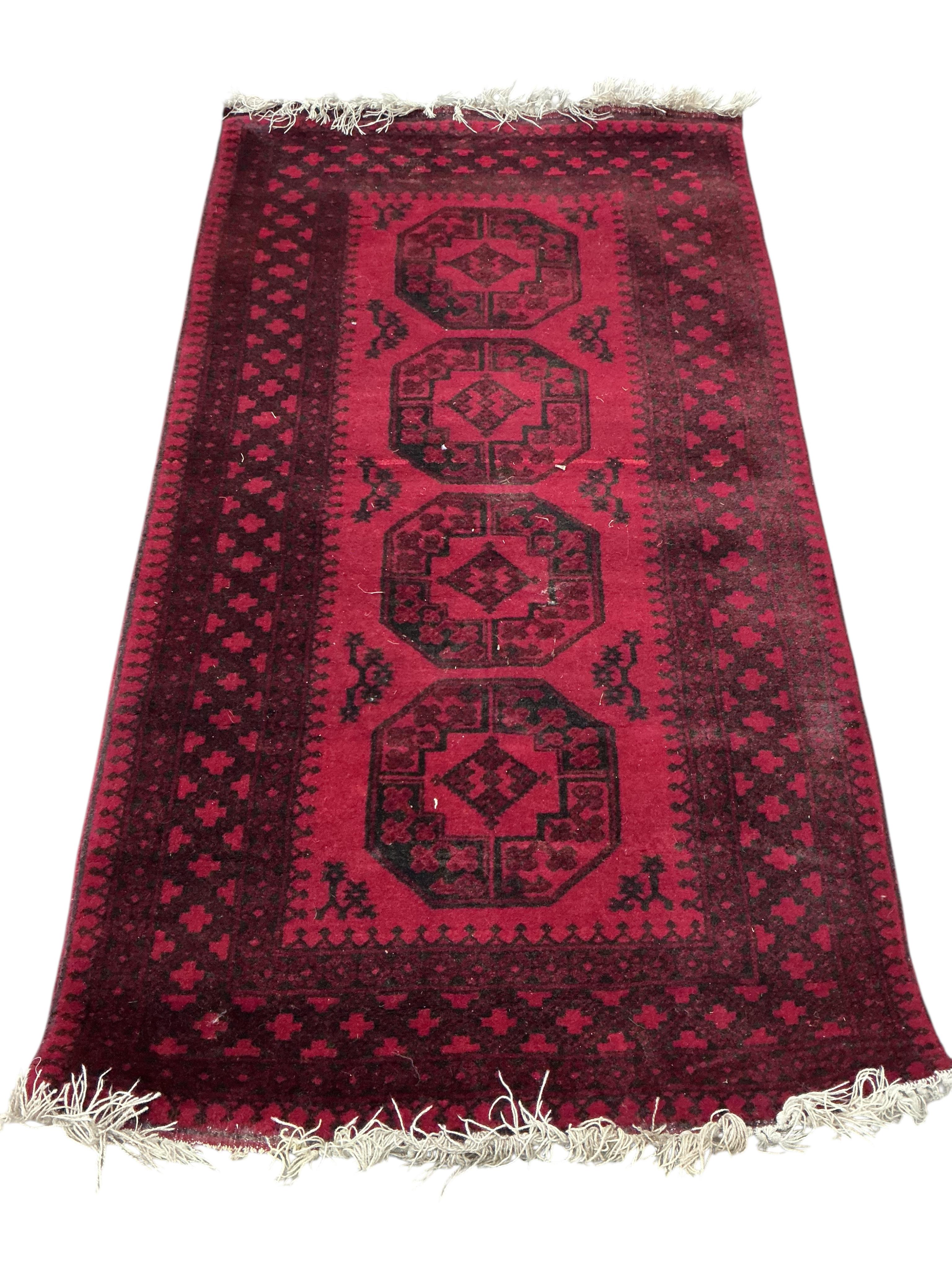 An Afgahn red ground wool rug, 200 x 108cm